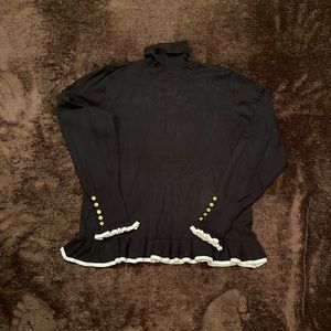 Black cotton blend turtle neck sweater with white ruffle trim. Size medium.
